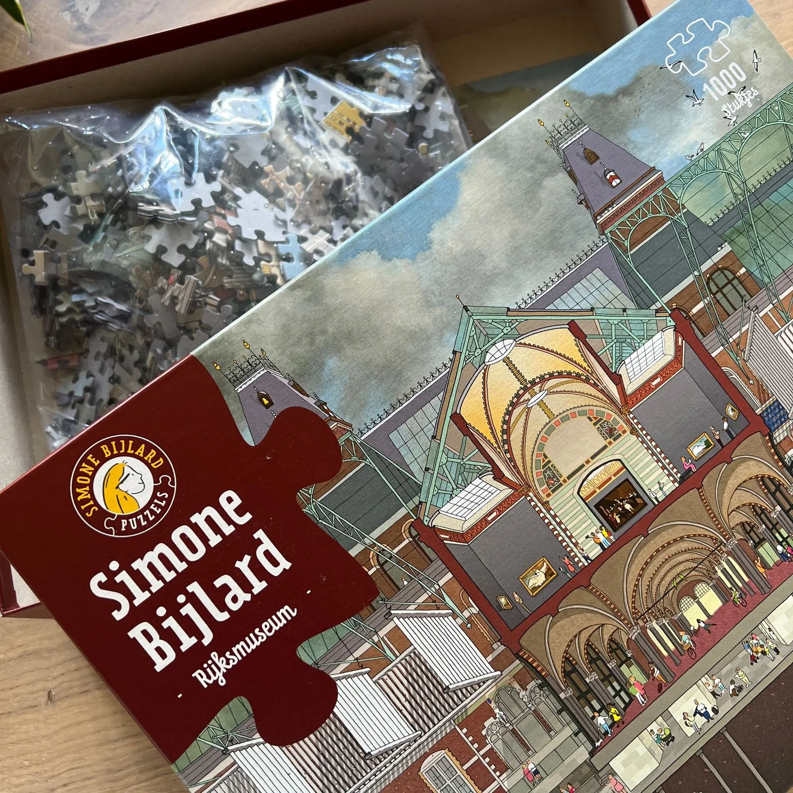 De doos van de legpuzzel Rijksmuseum open, met de stukjes in de zak